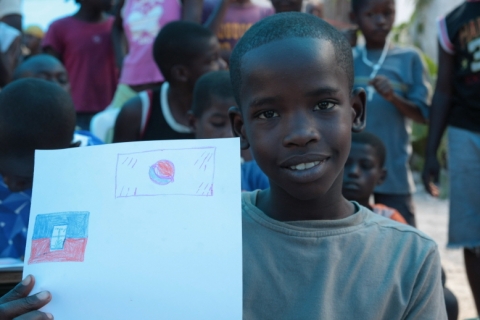 아이티의 한 아이가 태극기와 아이티 국기를 그려 보여주고 있다.