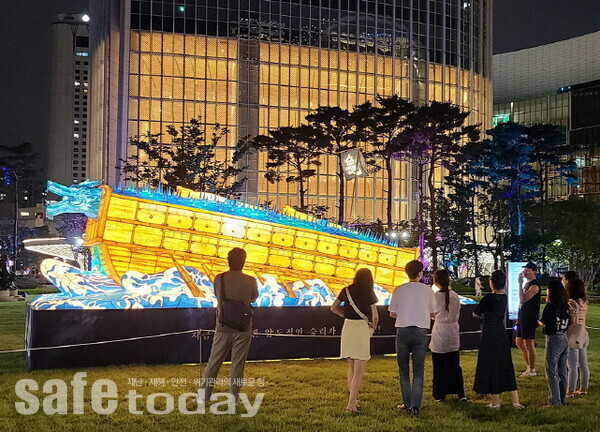 고객들이 영화 '한산 : 용의 출현' 대형 연등 전시를 즐기고 있다.